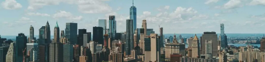 ნიუ-იორკის სკაილაინი One World Trade Center-ით ცისფერი ცისა და ღრუბლების ფონზე