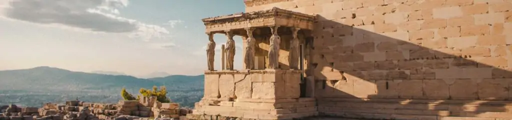 საბერძნეთის ხედი კოლონებითა და მწვანე მთებით ღრუბლიანი ცის ფონზე